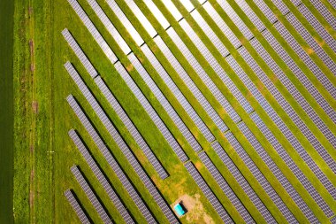 Yeşil alandaki güneş enerjisi santralinin havadan görüntüsü. Temiz ekolojik enerji üretmek için elektrik panelleri.