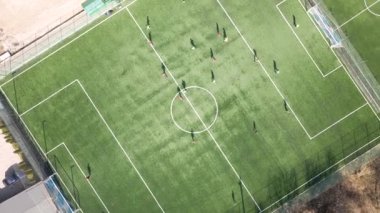 Yeşil spor stadyumunda futbol oynayan futbolcuların hava manzarası