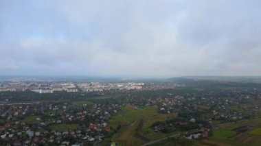 Yağmurdan önce oluşan kabarık kümülüs bulutlarıyla kaplı uzak şehrin yüksek irtifasından hava manzarası