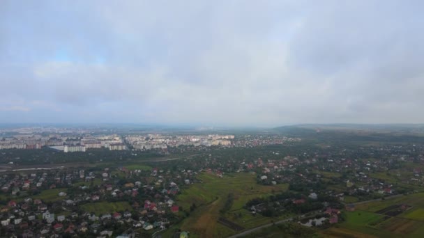 Воздушный вид с большой высоты далекого города, покрытый пышными кучевыми облаками, образующимися перед ливнем — стоковое видео