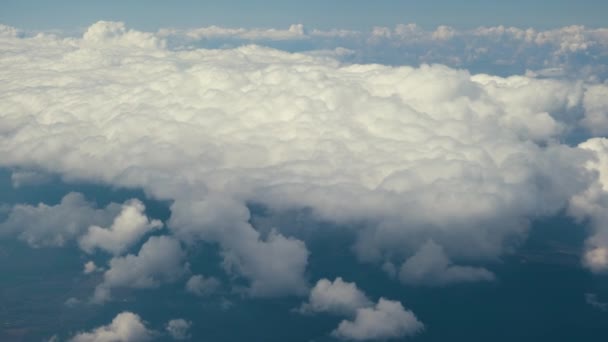 Vista aérea da janela do avião de nuvens inchadas brancas no dia ensolarado brilhante — Vídeo de Stock