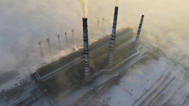 Воздушный вид на высокие трубы угольной электростанции с черным дымом, движущимся вверх загрязняющей атмосферу на восходе солнца — стоковое видео