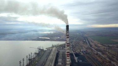 Kömür santralinden gelen gri dumanlı yüksek baca borularının havadan görüntüsü. Fosil yakıtla elektrik üretimi