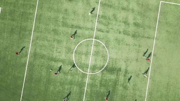 Aerial view of soccer players playing football on green sports stadium. — Stock Video