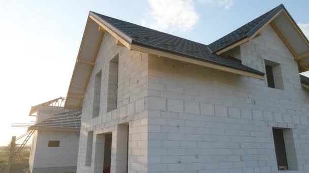 Vedere aeriană a casei neterminate cu pereți de beton ușor aerați și cadru de acoperiș din lemn acoperit cu plăci metalice în construcție. — Videoclip de stoc