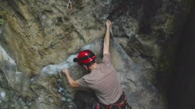 Kararlı dağcı kayalık dağın dik duvarına tırmanıyor. Sporcu zor yolu aştı. Ekstrem sporlar ve kaya tırmanışı hobileri..