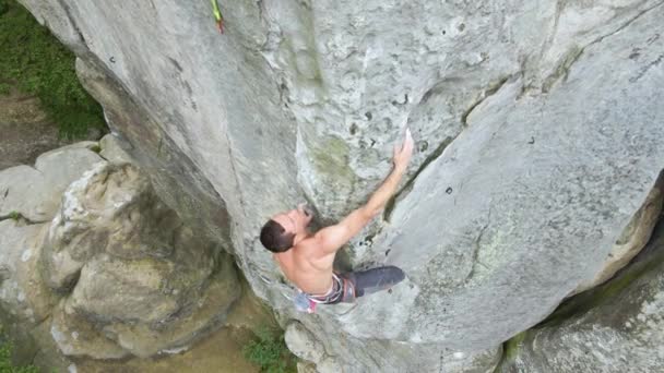 Escalador decidido trepando empinada pared de montaña rocosa. Deportista superando ruta difícil. Participar en deportes extremos y el concepto de hobby escalada en roca. — Vídeo de stock