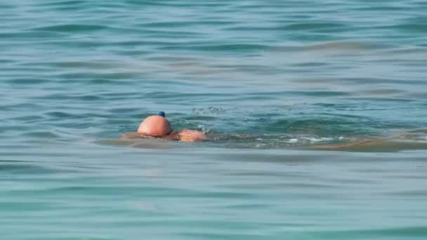 Nerozpoznatelný muž plavání s šnorchlování dýchací maskou pod hladinou mořské vody. — Stock video