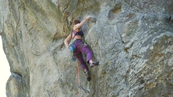 Ung kvinna klättrare faller ner efter misslyckad attemp att klättra brant mur av steniga berg. Engagera sig i extrema sport koncept. — Stockvideo