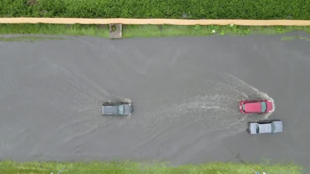 大雨の後に浸水通りを運転車と都市交通の空中ビュー。道路排水システムの問題. — ストック動画