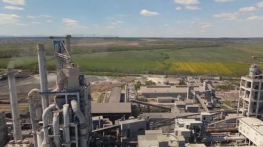 Yüksek beton yapısı olan çimento fabrikasının havadan görünüşü ve endüstriyel üretim alanında kule vinci. Üretim ve küresel sanayi kavramı