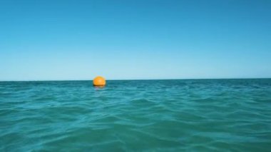 Deniz yüzeyinde yüzen sarı şamandıra, tropik tatil beldesindeki derin sularda yüzme kısıtlaması için bir işaret. İnsan hayatı güvenliği kavramı