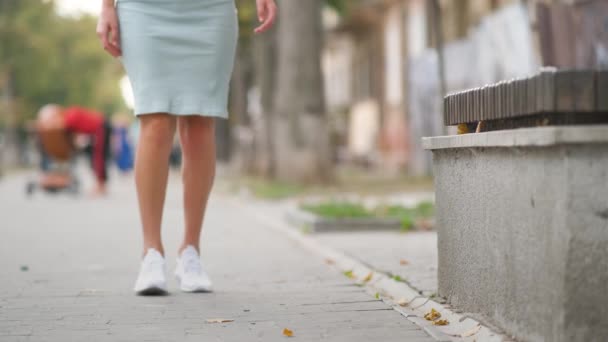 Primer plano de las manos de la mujer sosteniendo su rodilla con dolor sentado en el banco al aire libre — Vídeos de Stock