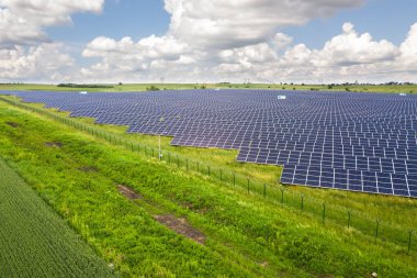 Yeşil alandaki güneş enerjisi santralinin havadan görüntüsü. Temiz ekolojik enerji üretmek için elektrik panelleri.