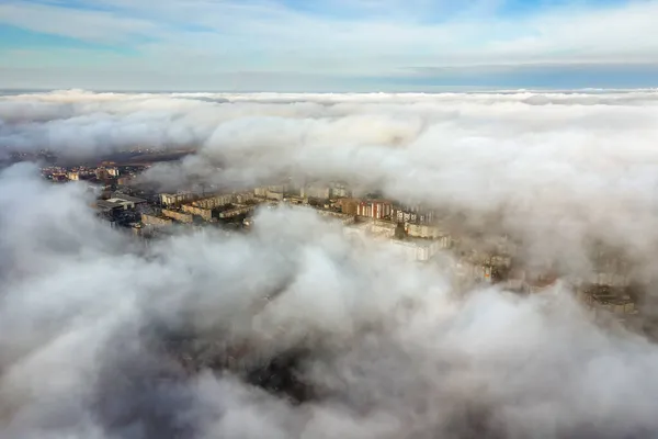 高層ビルが立ち並ぶ近代都市の上からのふわふわした白い雲の空中写真 — ストック写真