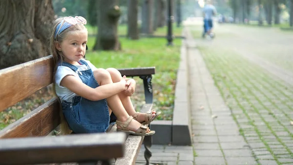 Klein Kind Meisje Zit Alleen Een Bank Zomer Park — Stockfoto