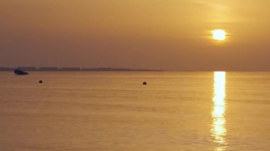 Büyük sarı güneş deniz yüzeyinde yükseliyor..