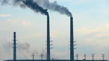 Termik santrale yakın siyah dumanlı yüksek borular atmosferi kirletiyor. Fosil yakıt kavramına sahip elektrik enerjisi üretimi