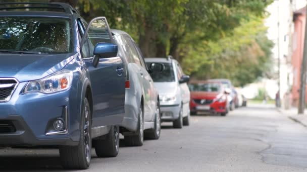 Conductora mujer bajándose de su coche y cerrándolo con llavero mientras se aleja por la calle de la ciudad. Concepto de seguridad del vehículo — Vídeos de Stock