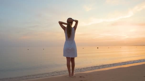 Tineri fericit femeie în picioare pe plaja de nisip de litoral bucurându-se de cald seara tropicală — Videoclip de stoc
