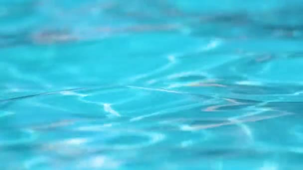 Superfície de close-up de água clara azul com pequenas ondas de ondulação na piscina — Vídeo de Stock