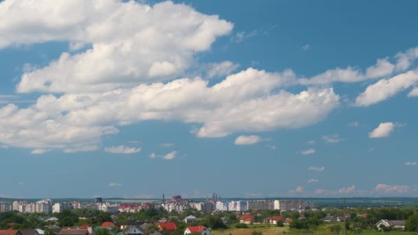Time lapse footage of fast moving white puffy cumulus clouds on blue clear sky over small houses in rural residential area — Stock Video