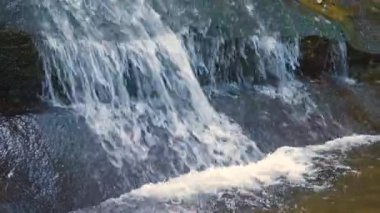 Sonbaharda kayalık kayalar arasında hızla akan temiz suyu olan küçük bir dağ deresi.