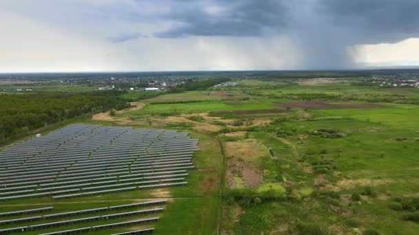 Вид с воздуха на большую устойчивую электростанцию со многими рядами солнечных фотоэлектрических панелей для получения чистой экологической электрической энергии. Возобновляемые источники энергии с нулевой концепцией выбросов — стоковое видео
