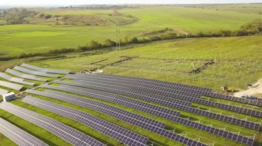 Yeşil alanda inşa halindeki güneş enerjisi santralinin havadan görüntüsü. Temiz ekolojik enerji üretmek için elektrik panellerinin montajı