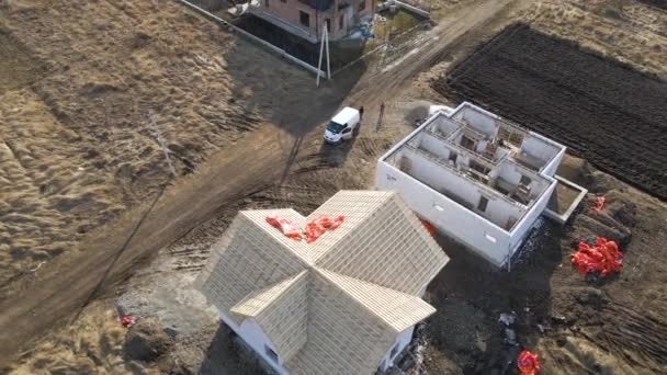 Vista aérea del marco inacabado de la casa privada con paredes de hormigón ligero aireado y marco de techo de madera en construcción — Vídeo de stock