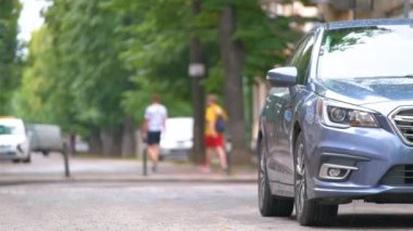 Sokak kenarında park halindeki arabalarla şehir trafiği