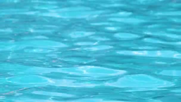 Surface rapprochée de l'eau claire bleue avec de petites vagues d'ondulation dans la piscine — Video