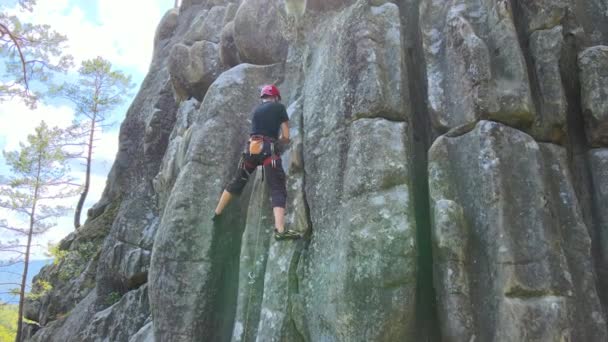 Pendaki pria yang kuat memanjat dinding curam gunung berbatu. Olahraga mengatasi rute yang sulit. Terlibat dalam konsep hobi olahraga ekstrim — Stok Video