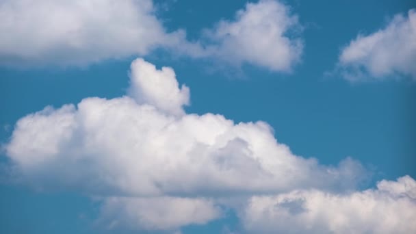 Time lapse footage of fast moving white puffy cumulus clouds on blue clear sky — Vídeo de Stock