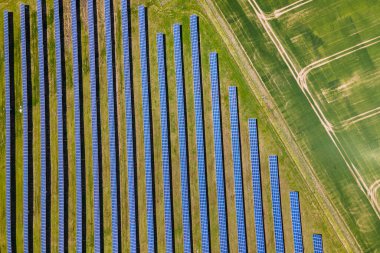 Temiz ekolojik elektrik enerjisi üretmek için birçok sıra güneş fotovoltaik paneli bulunan sürdürülebilir büyük elektrik santralinin havadan görünüşü. Sıfır emisyon kavramı ile yenilenebilir elektrik.