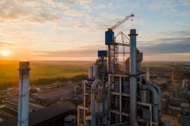 Yüksek beton fabrikası ve endüstriyel üretim alanında kule vinci olan çimento fabrikasının havadan görüntüsü. Üretim ve küresel sanayi kavramı.