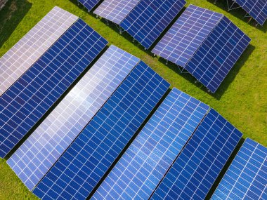 Temiz ekolojik elektrik enerjisi üretmek için sıra sıra güneş fotovoltaik panelleri olan sürdürülebilir büyük elektrik santralinin havadan görünüşü. Sıfır emisyon kavramı ile yenilenebilir elektrik.