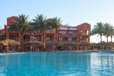 Mavi berrak su ve tropikal tatil köyündeki yüzme havuzunda küçük dalgalar. Yaz tatilleri konsepti.