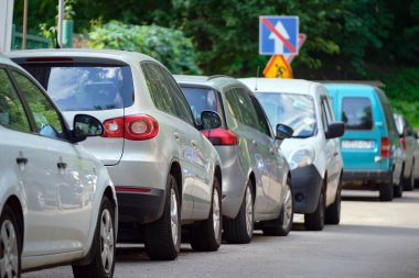 Sokak kenarında park halindeki arabalarla şehir trafiği.