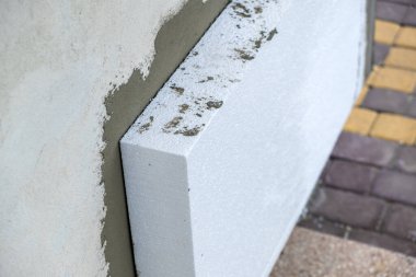 Termal koruma için ev cephesi duvarına köpük yalıtım çarşafları kurulumu.