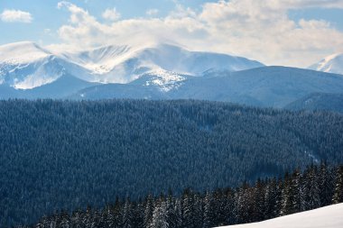 Soğuk kış günlerinde yoğun kar yağışı sonrası yüksek dağlık tepelerle kaplanmış kış manzarası..