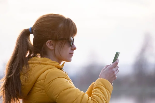 Jovem Mulher Bonita Sentada Banco Parque Navegando Seu Smartphone Livre — Fotografia de Stock