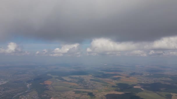 Vista aérea da janela do avião em alta altitude da terra coberta com nuvens cumulus inchadas que se formam antes da tempestade. — Vídeo de Stock