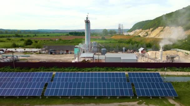 Ilmakuva sähkövoimalasta, jossa on rivejä aurinkosähköpaneeleja puhtaan ekologisen sähköenergian tuottamiseksi teollisuusalueella. Päästöttömän uusiutuvan sähkön käsite. — kuvapankkivideo