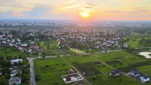 Flygfoto över bostadshus i en förort på landsbygden vid solnedgången. — Stockvideo