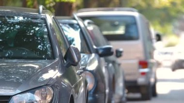 Sokak kenarında park halindeki arabalarla şehir trafiği.