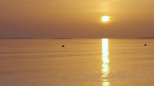 Большое желтое солнце поднимается над поверхностью моря. — стоковое видео