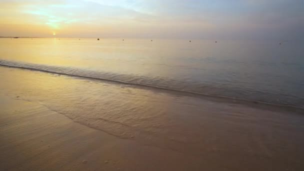 Côte de mer calme avec des vagues écrasantes sur la plage de sable au lever du soleil. — Video