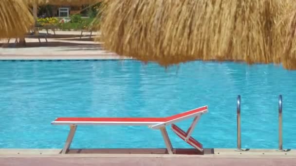 Silla de cubierta vacía en el lado de la piscina en el complejo de verano. Concepto de vacaciones y escapadas. — Vídeos de Stock