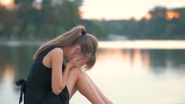 Mulher jovem triste sentado sozinho ao ar livre chorando amargamente. Conceito de depressão e emoções. — Vídeo de Stock